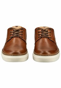 Zapatos de cuero marrón con un acabado suave, punta redonda y suelas de goma beige. Los cordones son marrones, con un acento de cuero beige en la lengüeta.