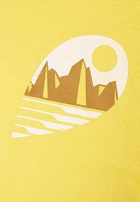 Camiseta amarilla con un gráfico de montañas y un sol en blanco y marrón, con líneas curvas que representan agua debajo. Textura de tela suave.
