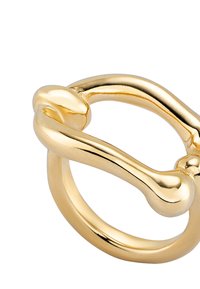 Anillo de oro con un acabado liso y brillante, con un lazo y un detalle de diseño en forma de hueso alargado. Bordes redondeados y textura pulida.