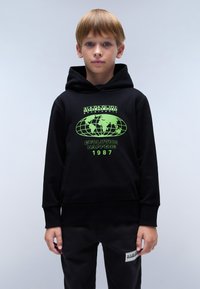 Zwarte hoodie met een voorkantgrafiek in felgroen, met een wereldbolontwerp en tekst. Geribde manchetten en zoom, gecombineerd met zwarte broek.