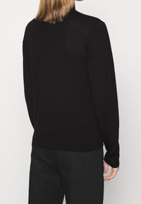 Schwarzer Pullover mit langen Ärmeln, geripptem Saum und Bündchen, aus feinem Strickmaterial gefertigt und mit einem schlichten und klaren Design.