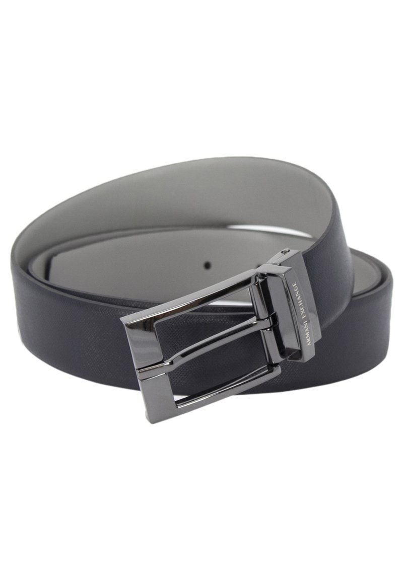 Zwarte leren riem met een strakke afwerking, zilveren metalen gesp in een rechthoekige vorm, hoogwaardig logo en een minimalistisch ontwerp.