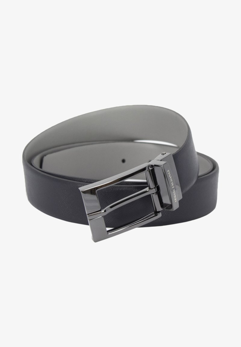 Cinturón de cuero negro con un acabado suave, hebilla de metal plateado con forma rectangular, logo en relieve y un diseño minimalista.