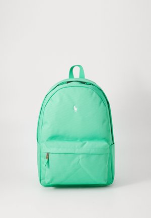 Zelena torba u boji mente napravljena od tkanine, s okruglim oblikom, gornjom ručkom, prednjim džepom i malim bijelim logotipom sprijeda.