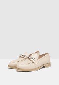 Beige læder loafers med en metal kæde detalje, rund tå og en stablet træhæl. Glat tekstur med minimal syning.