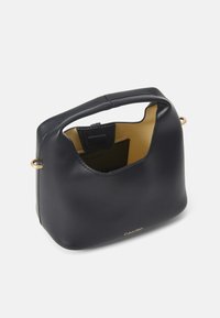 Černá kožená kabelka, zaoblený design, krátká rukojeť, zlaté kovové akcenty, vnitřek má kontrastní přírodní podšívku. Viditelné logo Calvin Klein.