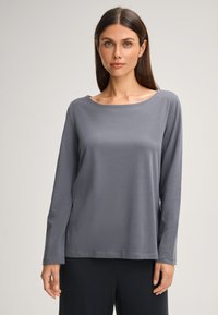 Šedá dlouhá rukávová košile s širokým kulatým výstřihem, vyrobená z měkké látky. Obsahuje uvolněný střih a hladký, nezdobený design.