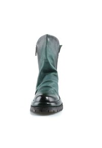 Vue de face d'une botte mi-mollet en cuir vert avec un bout rond noir et une semelle en caoutchouc épaisse sur fond blanc.