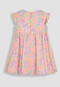 Vestido de algodón floral en rosa pastel con mangas con volantes, presenta flores moradas y acentos verdes, cierre de botones en la parte posterior y falda plisada.