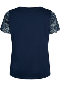 Camiseta de manga corta en color navy con detalle de encaje en los hombros. Tela suave con un escote redondo y borde de encaje festoneado. Corte casual.