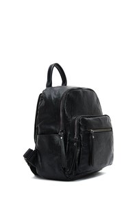 Zaino in pelle nera con superficie strutturata. Presenta diverse tasche con zip, una maniglia superiore e spallacci regolabili.