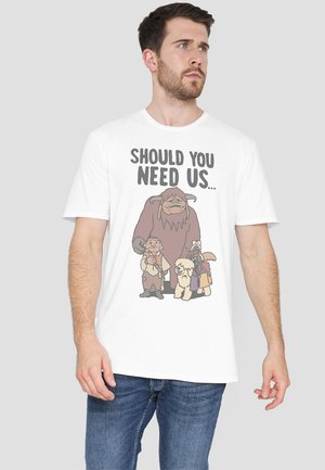 White cotton t-shirt featuring a graphic print of characters, with the text "SHOULD YOU NEED US..." in bold black letters.