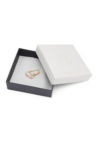 Goldene Creolen mit klaren und orangefarbenen Edelsteinen, präsentiert in einer grauen, mit Samt ausgekleideten schwarzen Schachtel mit einem strukturierten weißen Deckel.