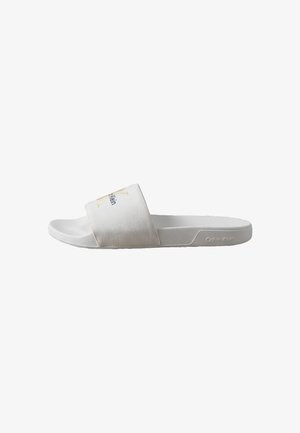 Sandalia tipo pala blanca de Calvin Klein con tirante de tela texturizada y logo en relieve en el lateral de la suela.