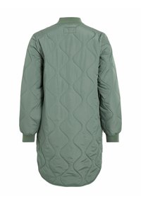 Žalia ilga dygsniuota striukė su lenkta bangos rašto išraiška, riboto apykakle ir rankogaliais bei ilgesniu užpakaliniu kraštu. Lygi, lengva medžiaga.