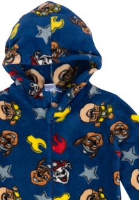 Tuta in pile con sfondo blu decorato con cani cartoon e stelle, chiusura con zip frontale e cappuccio. Tessuto morbido e colori vivaci.