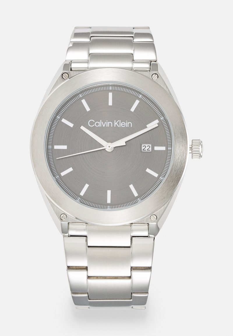 Reloj de acero inoxidable plateado con un dial gris, marcadores de hora blancos, ventana de fecha a las 3 en punto y una pulsera de eslabones metálicos pulidos.