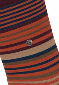 Calzino a righe arancio, borgogna, marrone e blu. Presenta un bottone rotondo in argento con la scritta "ci teniamo" al centro. Materiale a maglia testurizzato.