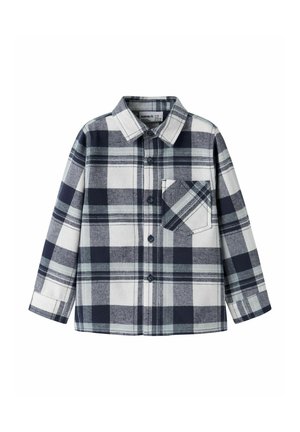 Chemise à manches longues boutonnée avec un motif à carreaux noir, blanc et gris et une poche poitrine frontale avec un motif à carreaux en diagonale.