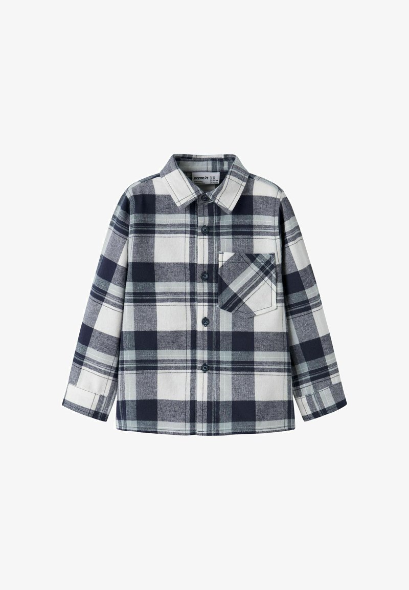 Chemise à manches longues boutonnée avec un motif à carreaux noir, blanc et gris et une poche poitrine frontale avec un motif à carreaux en diagonale.