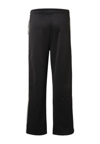 Čierne široké teplákové nohavice s elastickým pásom a bielymi pruhmi pozdĺž vonkajších strán nôh, zobrazené zozadu.