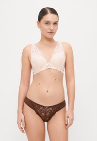 Reggiseno in pizzo di un delicato rosa con bordi scallop, abbinato a slip in pizzo color marrone con motivi floreali e pannelli in rete.