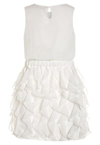 Vestido blanco sin mangas con un cuerpo liso, espalda con abertura en forma de llave y una falda que presenta detalles de tela con volantes en capas.