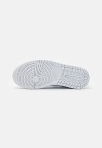 Witte sneakerzool met cirkelvormige en lineaire looppatronen. Glad oppervlak en het Nike-logo is in de middenzool geperst. Schoon, modern ontwerp.