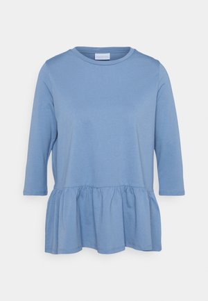 Haut femme bleu clair à manches longues, col rond et bas peplum froncé à la taille.