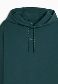 Felpa verde scuro con cappuccio regolabile, lacci strutturati e un logo discreto sul petto, realizzata in un tessuto morbido e traspirante.