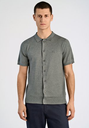 Polo de manga corta en tejido de punto gris jaspeado, con cierre de botones en la parte delantera, cuello acanalado y un sutil logo bordado en el pecho.