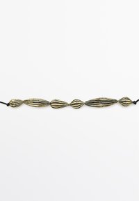 Bronzen armband met verlengde, geribbelde vormen, die afwisselend ronde en spitse uiteinden hebben, vastgemaakt met een zwarte koord.