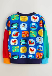 Multifarvet sweatshirt med blå bund, der har festlige mønstre, herunder kræfthvaler, snemænd og gaver. Ribbet manchetter i rød og grøn.