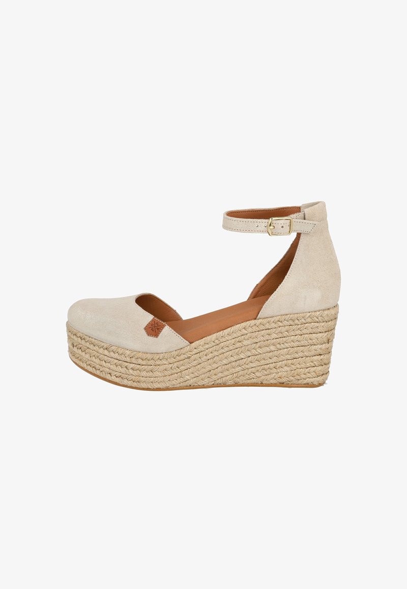 Zapato de cuña de ante beige con tira en el tobillo, diseño de puntera abierta, base envuelta en yute y pequeño detalle de cuero en el empeine.