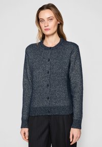 Tmavě modrý pletený cardigan s kulatým výstřihem, který má zapínání na knoflíky, žebrované manžety a pas a měkký, strukturální povrch.