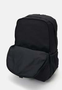 Sort rygsæk lavet af slidstærkt stof, med en lynlåset hovedrum, en stor frontlomme og mesh sidetasker til ekstra opbevaring.