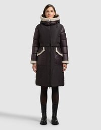 Ciemnobrązowy pikowany płaszcz z kapturem podszytym futrem, wyposażony w boczne kieszenie, pasek w talii oraz zapięcie na suwak. Matowe wykończenie z kontrastującymi fakturami.