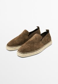 Brune ruskind slip-on sko med rund tå, snøre detaljer på sålen og en glat overflade. Minimalistisk design uden synligt hardware.