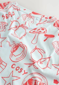 Világoskék anyag, piros vonalrajzokkal gombákról, körtékről, egy gőzölgő csészéről, csillagokról, valamint a "SEAS" és "COSY" feliratokkal.