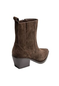 Bottine en suede marron avec un talon bloc empilé, des panneaux latéraux élastiques et une languette à l'arrière.