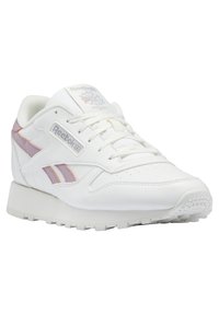Baskets lifestyle blanches Reebok avec bandes latérales roses et orange, laçage à l'avant et logos de marque sur la languette et les côtés.