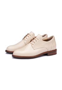 Scarpe da uomo in pelle beige con finitura liscia, punta rotonda, design con lacci e tacco in legno, caratterizzate da cuciture e dettagli sottili.