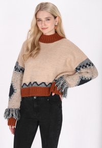 Beige kötött pulóver, rozsdabarna bordázott gallérral. Geometrikus mintákkal rendelkezik szürke és sötétkék színekben, bojtokkal és gyöngyökkel díszítve.