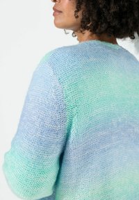 Kevyt neulottu neule, jossa on sininen ja mintunvihreä ombré-kuvio, joka esittelee tekstuurisen pinnan ja rentoa istuvuutta.