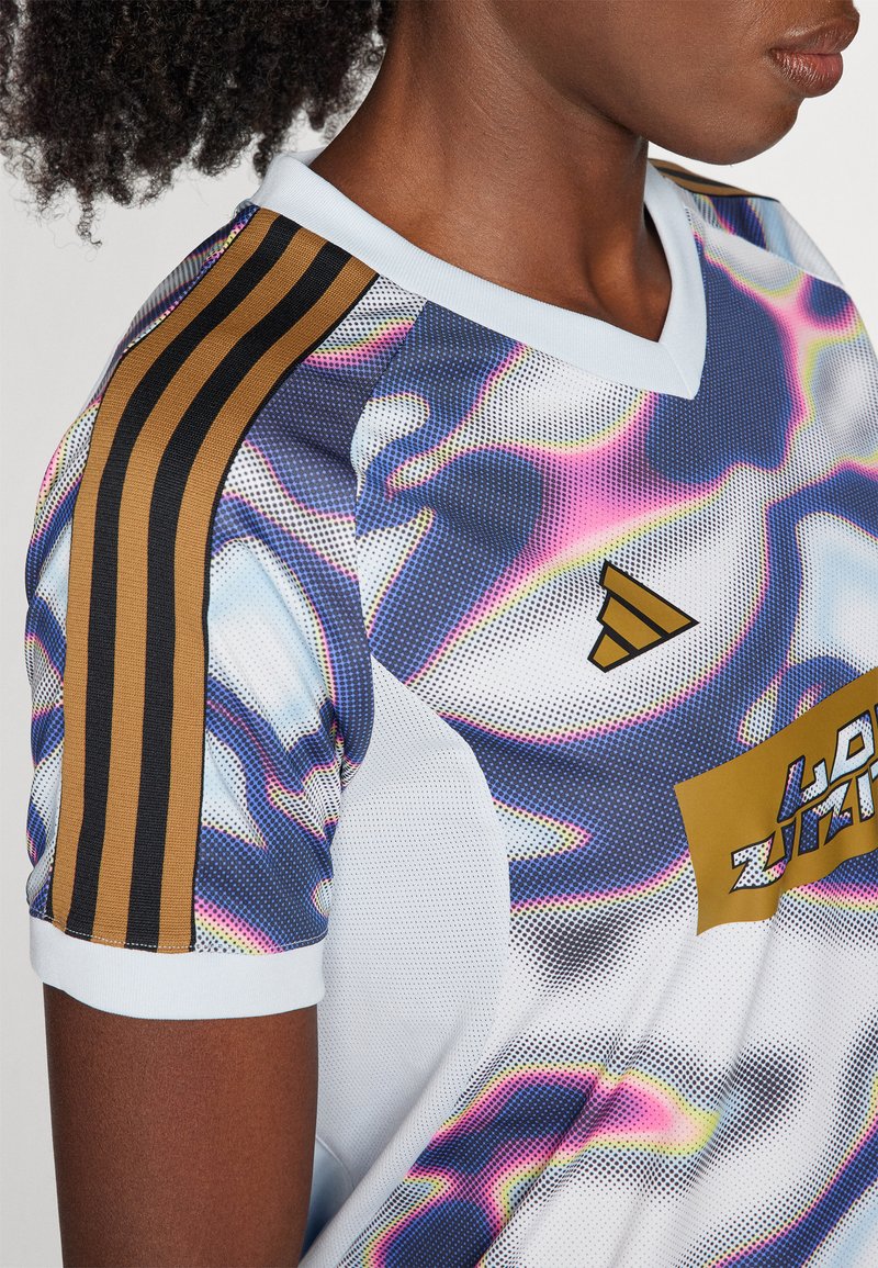 Kurzarmtrikot aus Mesh mit einem bunten abstrakten Muster. Weiße Basis mit blauen und rosa Akzenten sowie goldenen Streifen auf den Schultern.