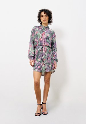 Korte mouw jurk met een kraag, voorzien van een multikleurig bloemenpatroon op textuurstof, op de taille bijeen gebonden met een bijpassende strik. Zwarte hakken.