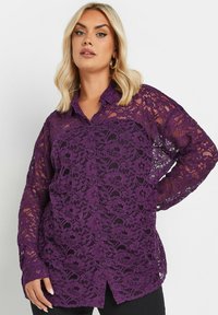 Purple lace shirt with a button-up front, long sleeves, floral patterns, and an open weave texture. Features a collar and slightly relaxed fit.