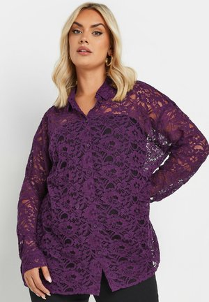 Purple lace shirt with a button-up front, long sleeves, floral patterns, and an open weave texture. Features a collar and slightly relaxed fit.