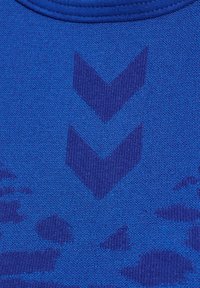 Blauwe stof met een gestructureerd oppervlak, versierd met donkerblauwe chevronpatronen en abstracte vormen, waardoor een dynamisch visueel effect ontstaat.