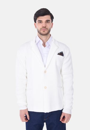 Blazer bianco a maglia con chiusura a un bottone, due tasche frontali e un fazzoletto decorativo. Tessuto testurizzato e vestibilità comoda.